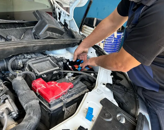 Mecánico trabajando en el motor de un coche
